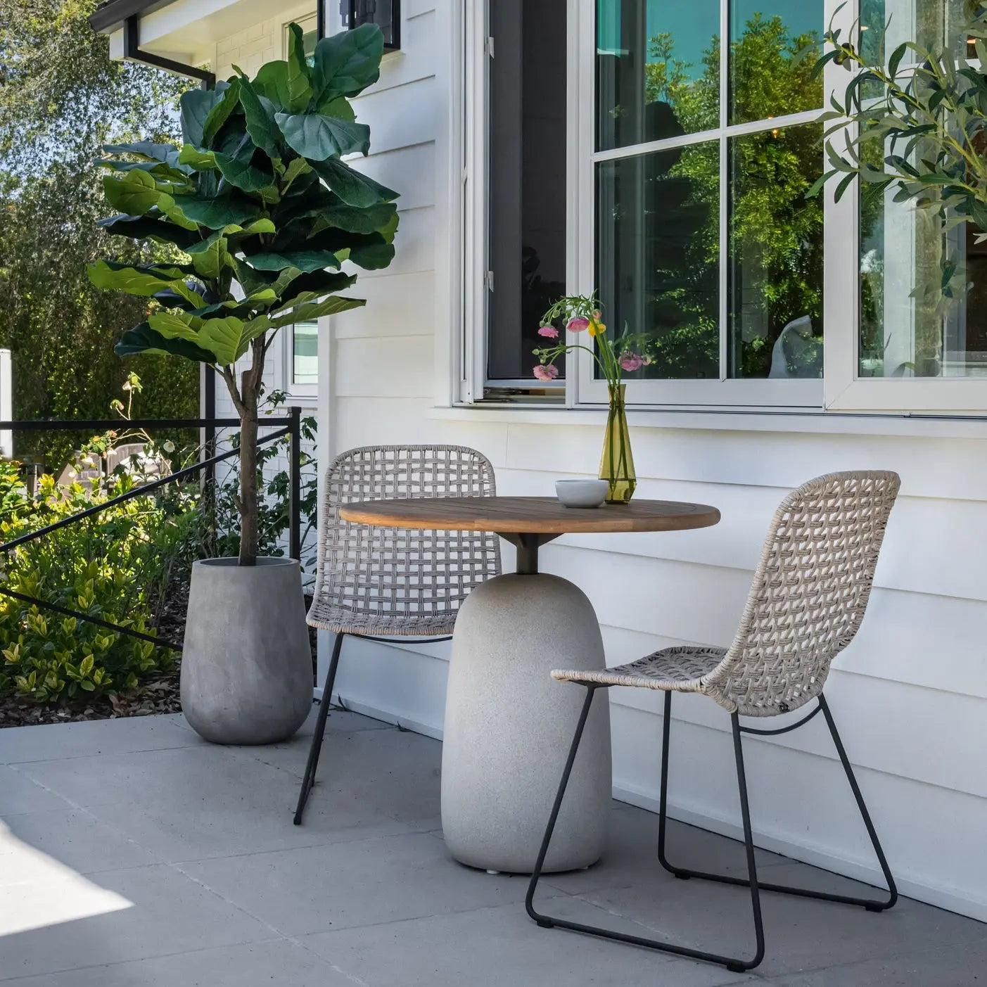 Modern outdoor patio table with two woven chairs