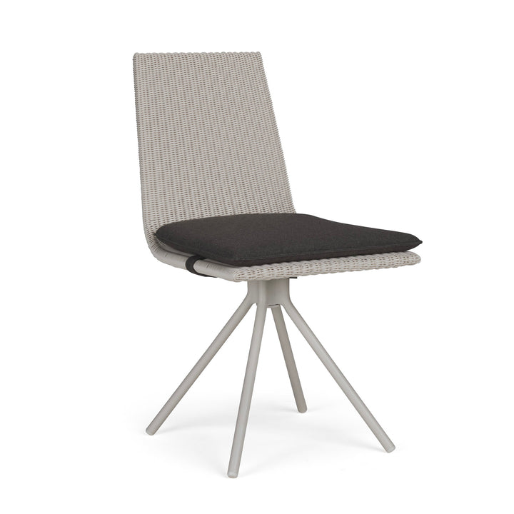 A light gray woven chair with a dark cushion sits atop four angled legs. The backdrop is plain, emphasizing the chair's modern and minimalist design.