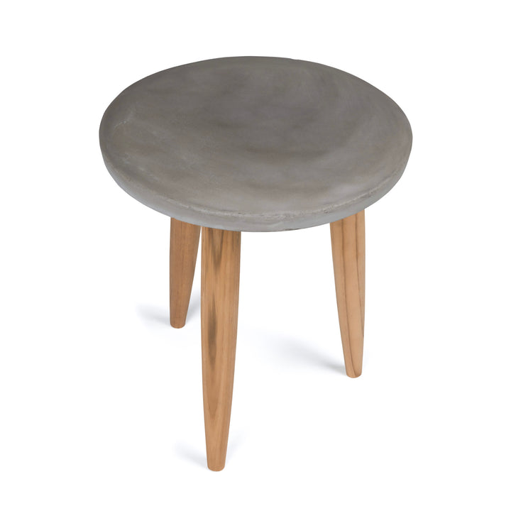 A round, gray concrete stool rests on three wooden legs, standing upright against a plain white background.