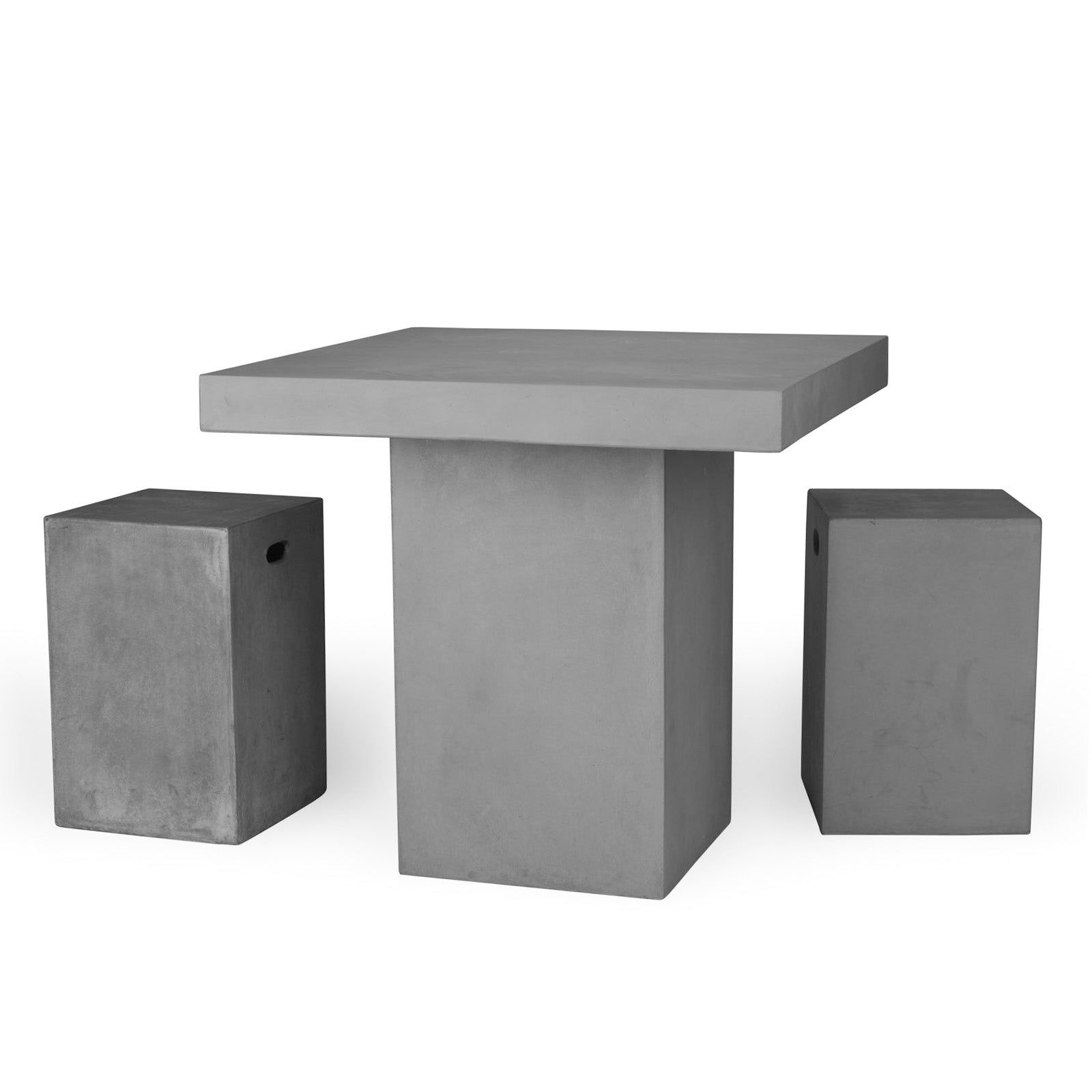 A rectangular, concrete table is flanked by two matching stools with handle cutouts, set against a plain white background.