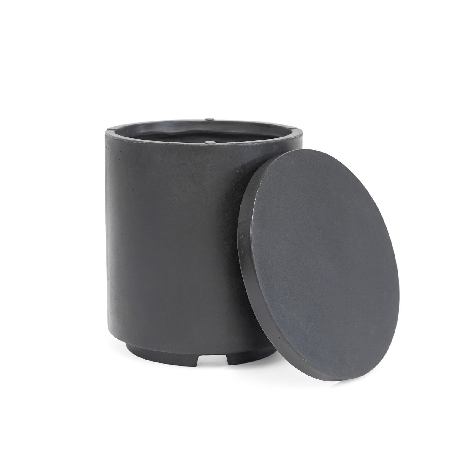 A cylindrical, matte black container with an open top sits on a white background. Its matching round lid leans against its side, slightly off-center.