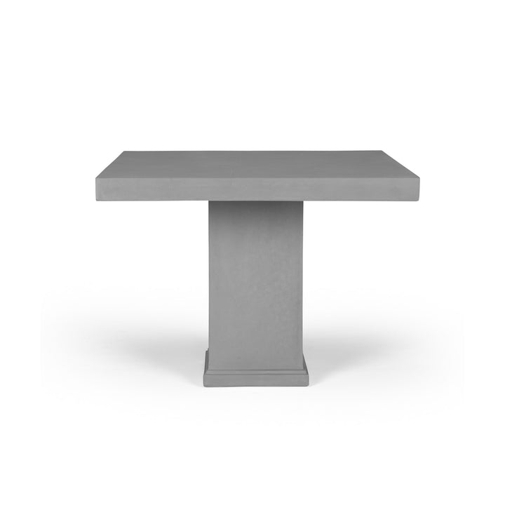 A gray, rectangular table with a thick top rests on a sturdy, square pedestal base, set against a plain white background.