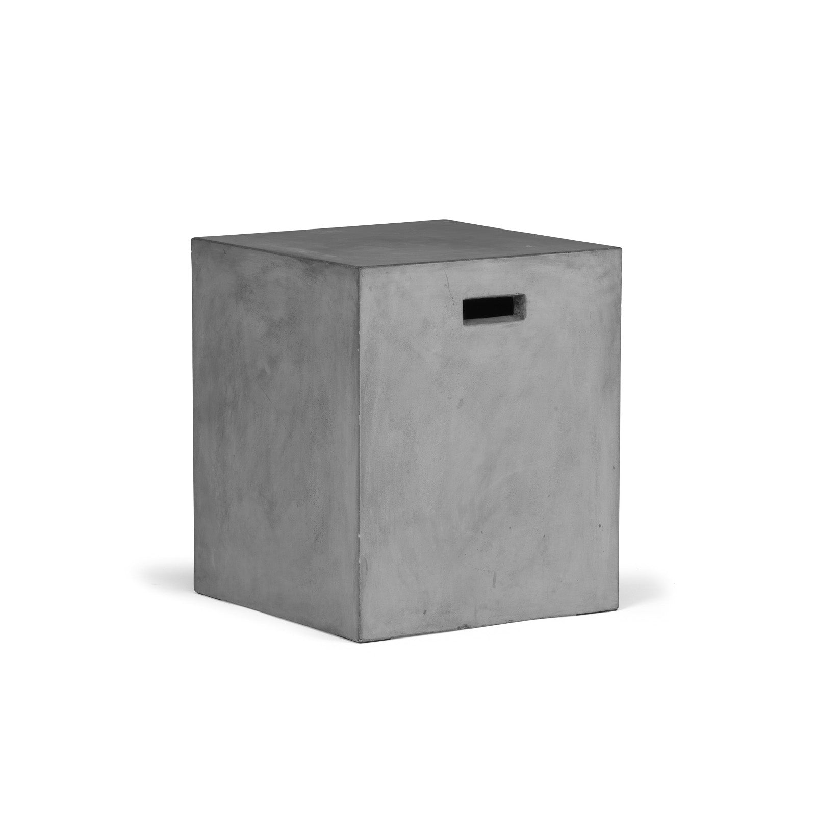 A concrete cube with a rectangular cutout on one side rests on a white background, suggesting a minimalist design or potential storage functionality.