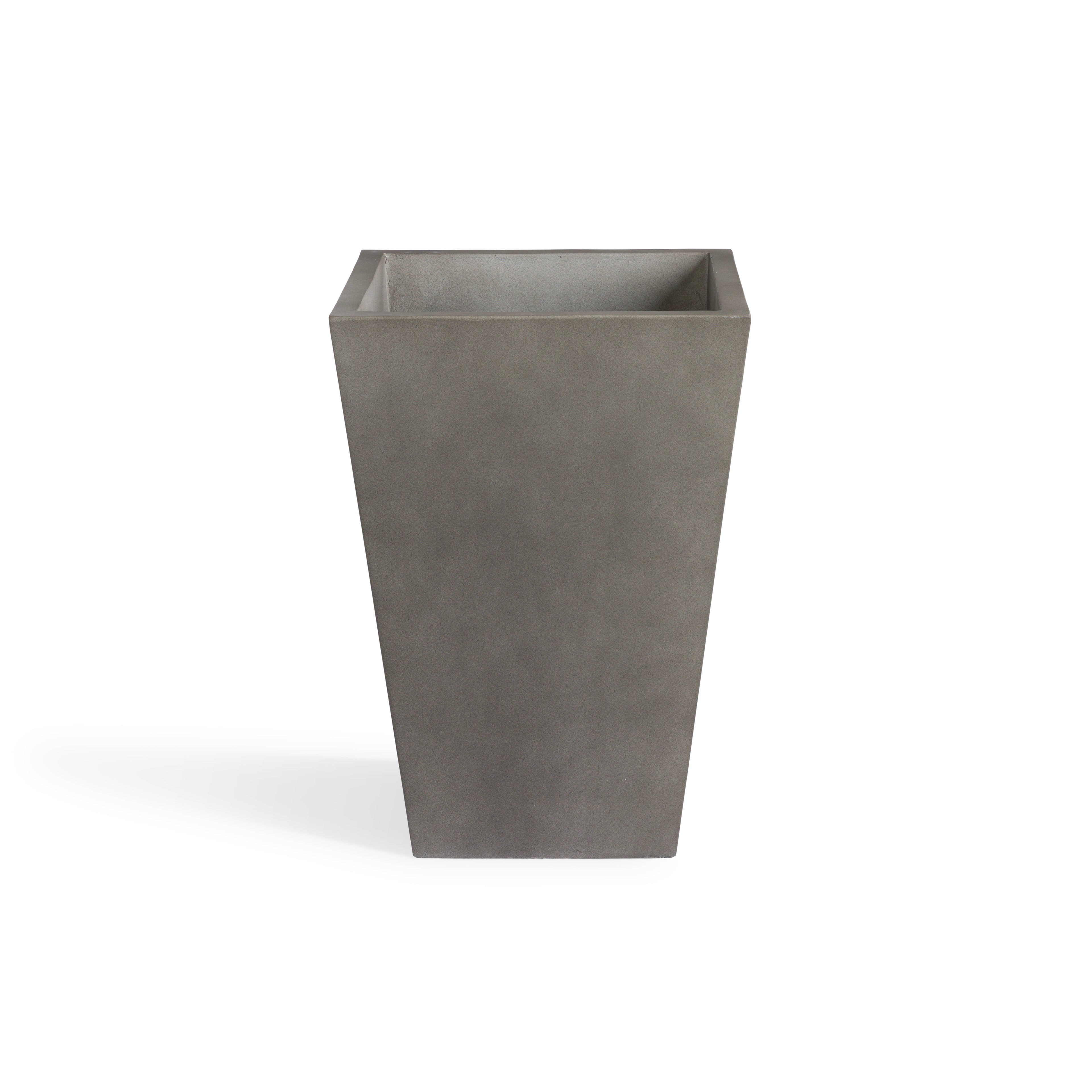 A tall, square, concrete planter stands upright against a plain white background, casting a subtle shadow to its left side.