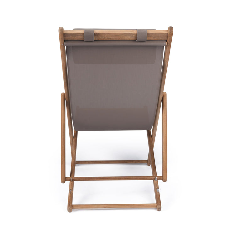 A canvas sling seat rests on a wooden folding frame, viewed from the back. The frame's simple design suggests portability or outdoor use, set against a plain white background.