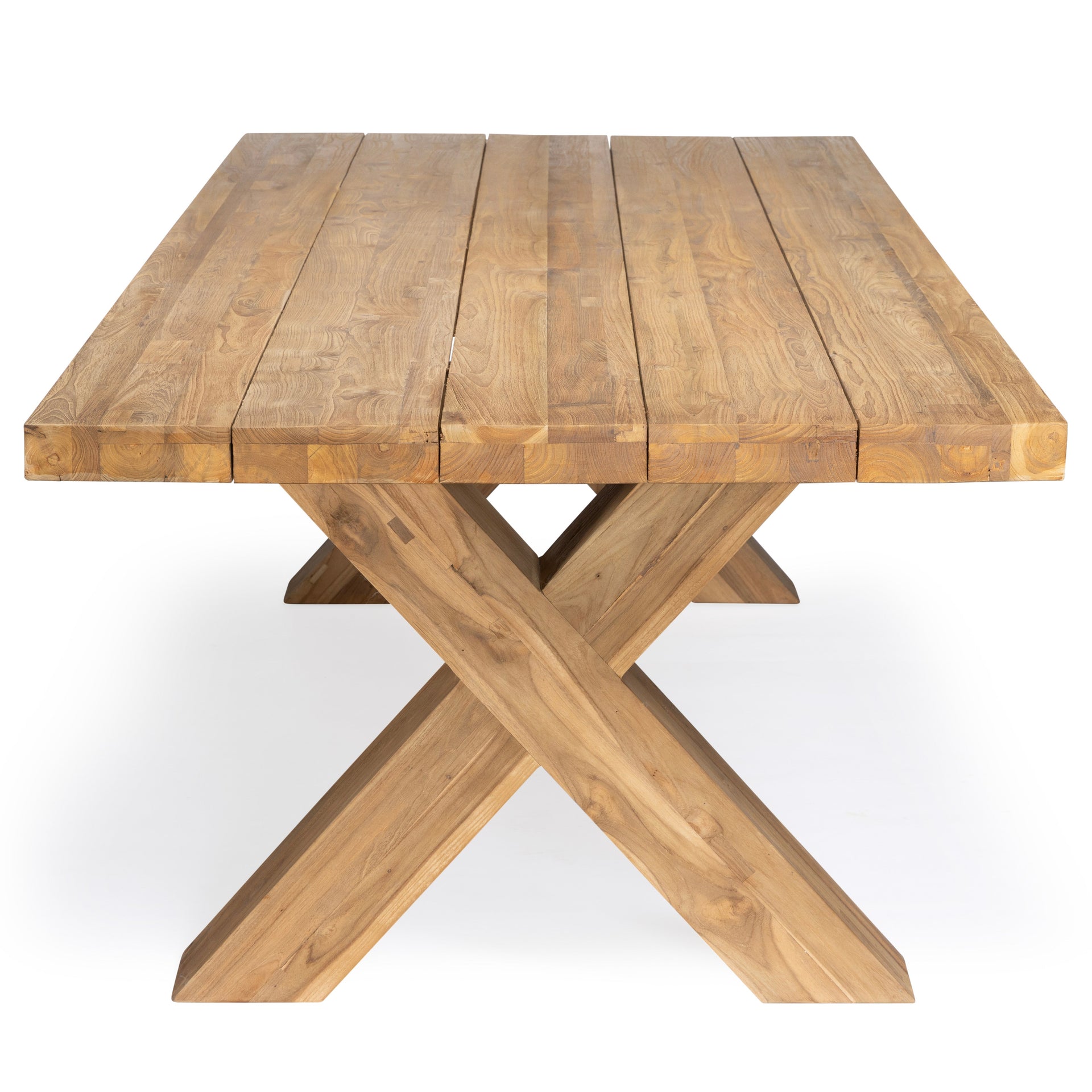 A wooden table with a plank-style top, supported by crossed legs, stands in a plain, white setting.