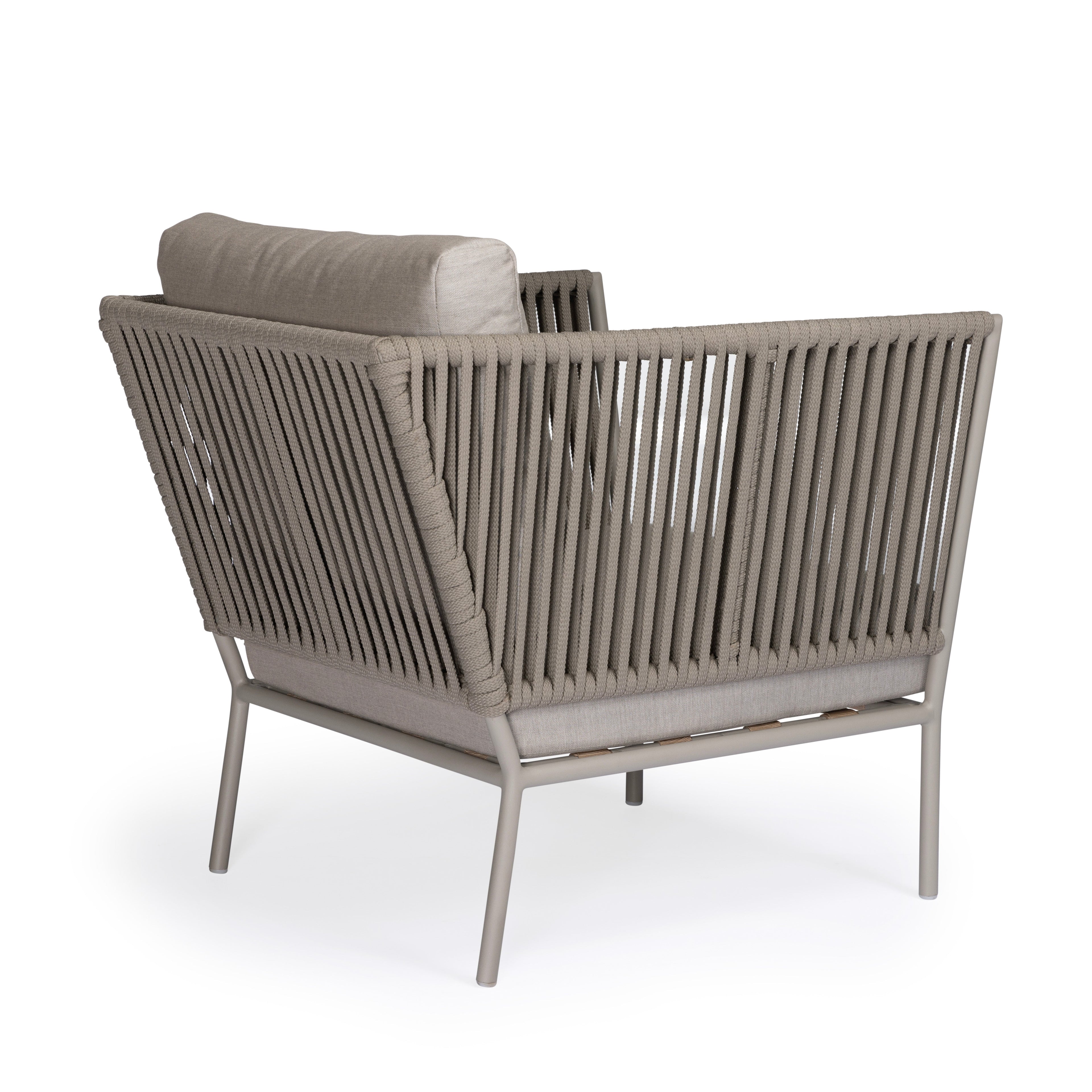 A beige cushioned armchair with a woven rope design sits on a metal frame, placed in a minimalist white setting.