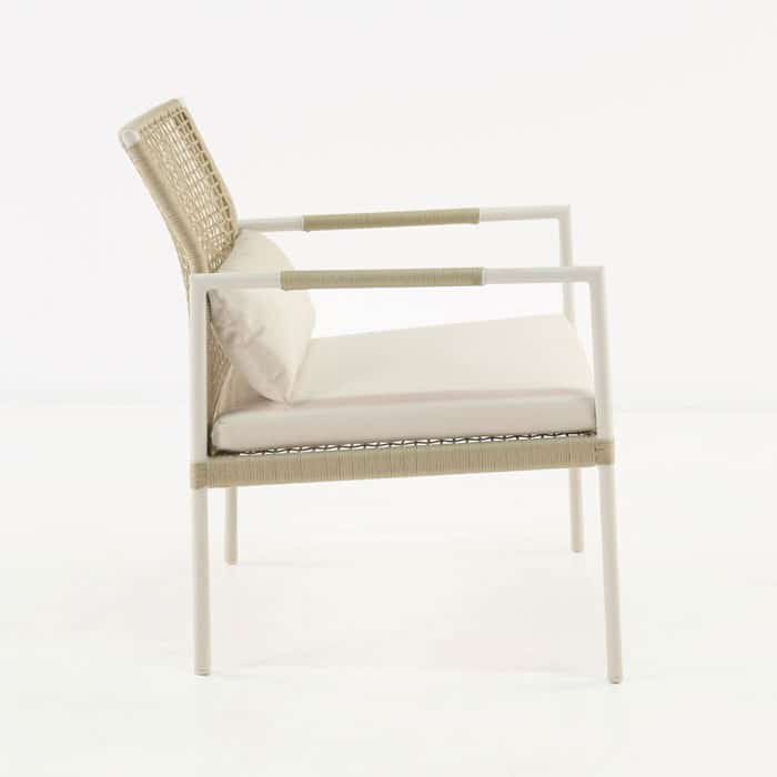 A beige and white outdoor chair with a woven back and cushioned seat is positioned on a plain, white background.