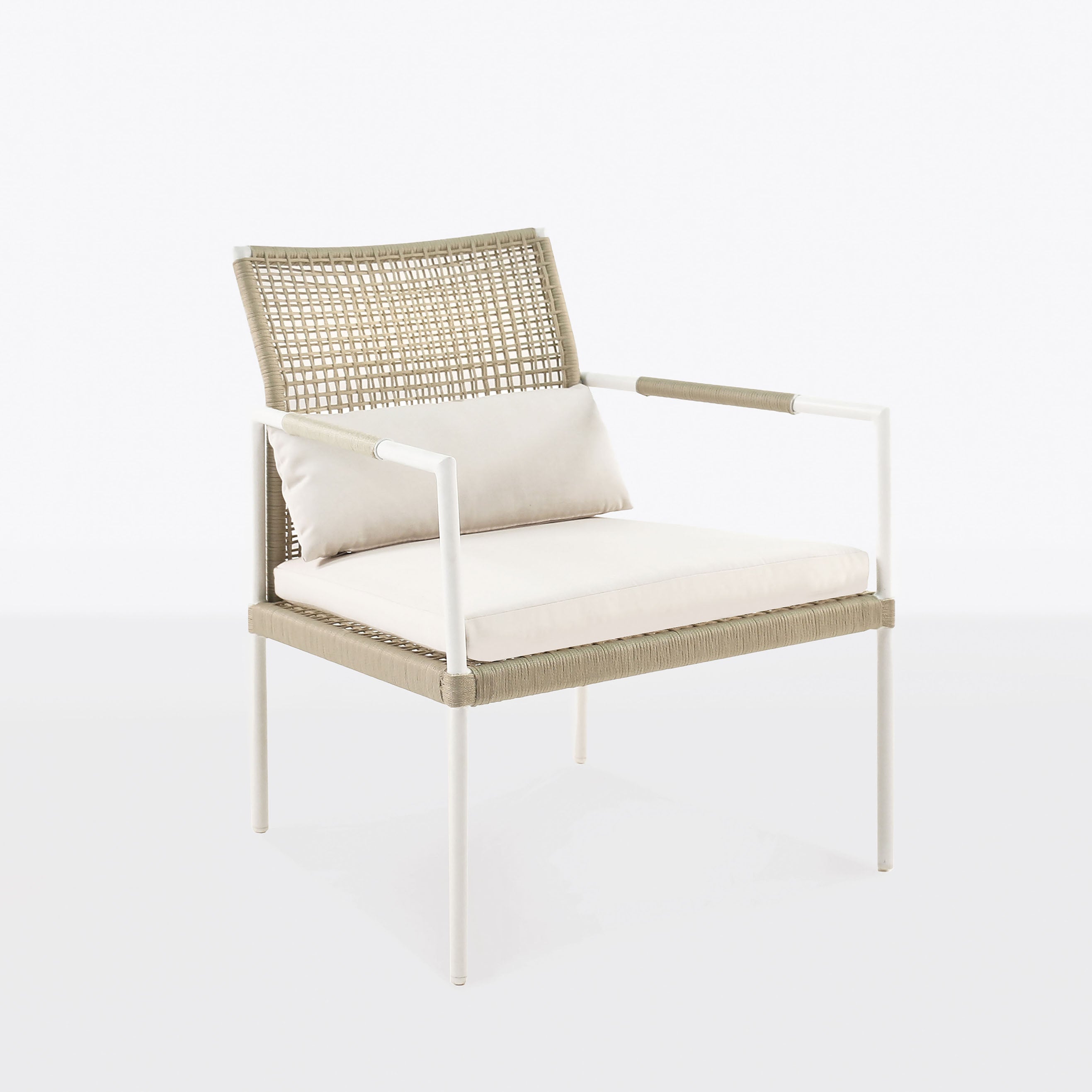 A beige and white chair with a woven backrest and armrests sits empty, featuring a cushion on a white metal frame, in a plain, light-colored space.