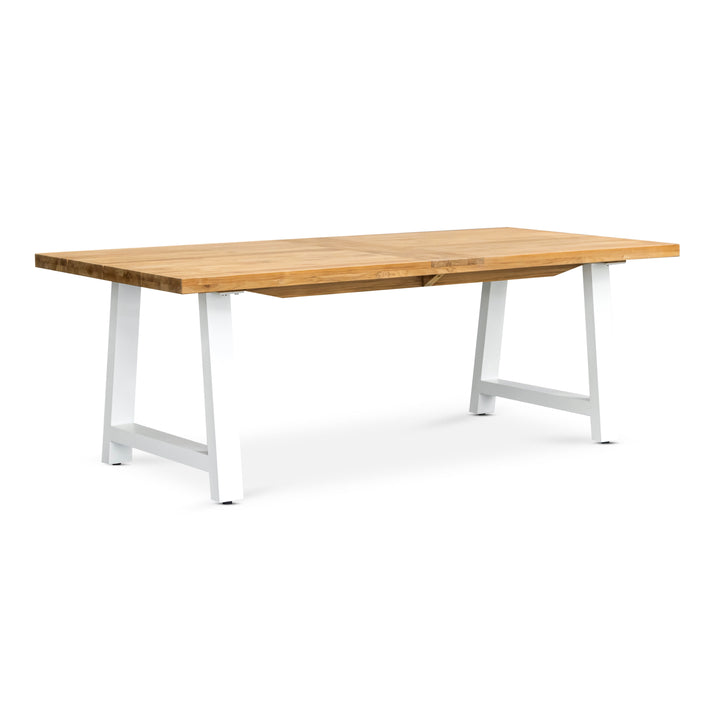 A rectangular wooden table with a smooth top rests on white metal legs, positioned against a plain white background.