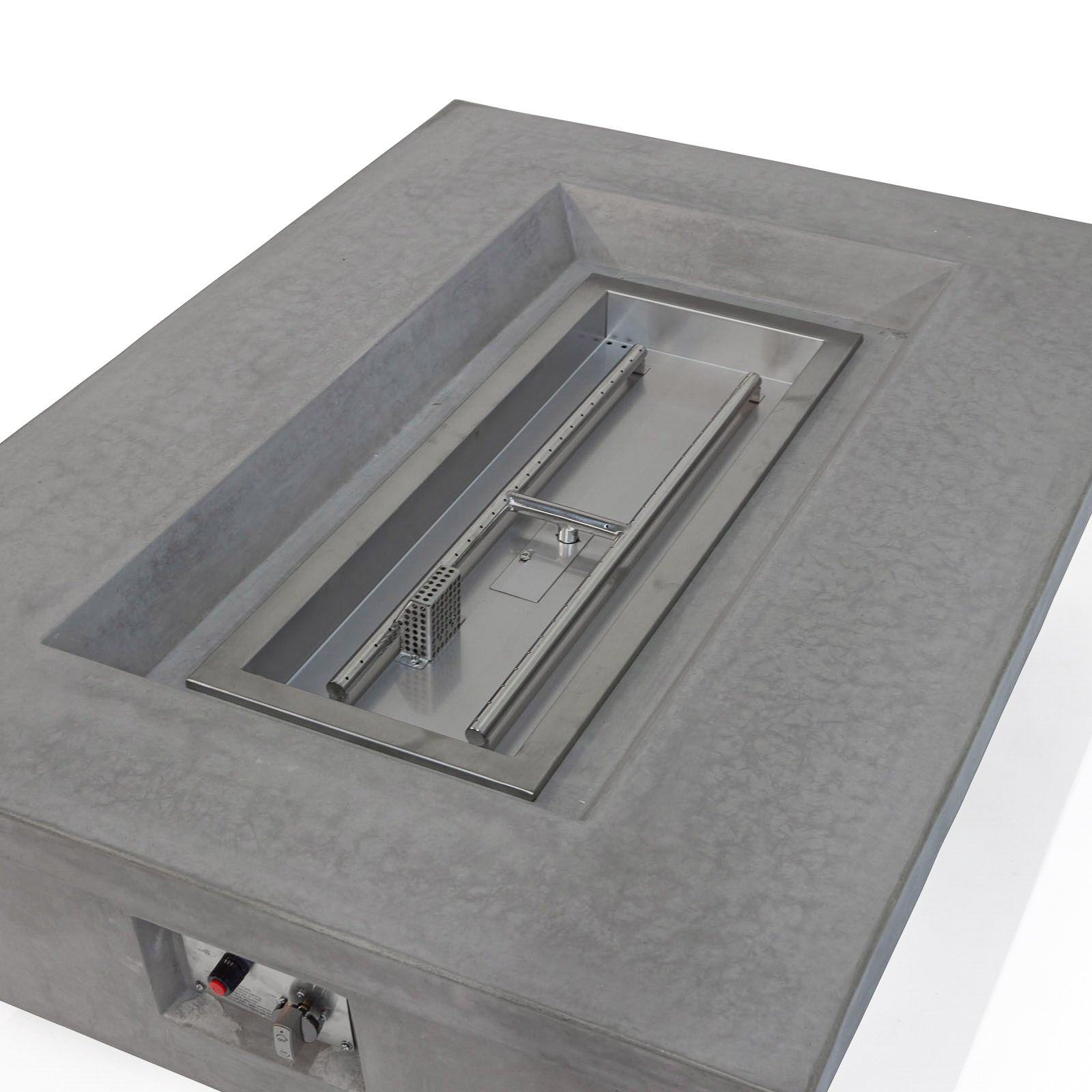 Rectangular concrete fire pit housing a metal burner system; situated in an indoor space with details of control knobs visible in a recess on the side.