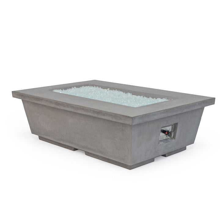 Rectangular concrete fire pit filled with white fire glass, having a control panel on the side, situated on a white background.