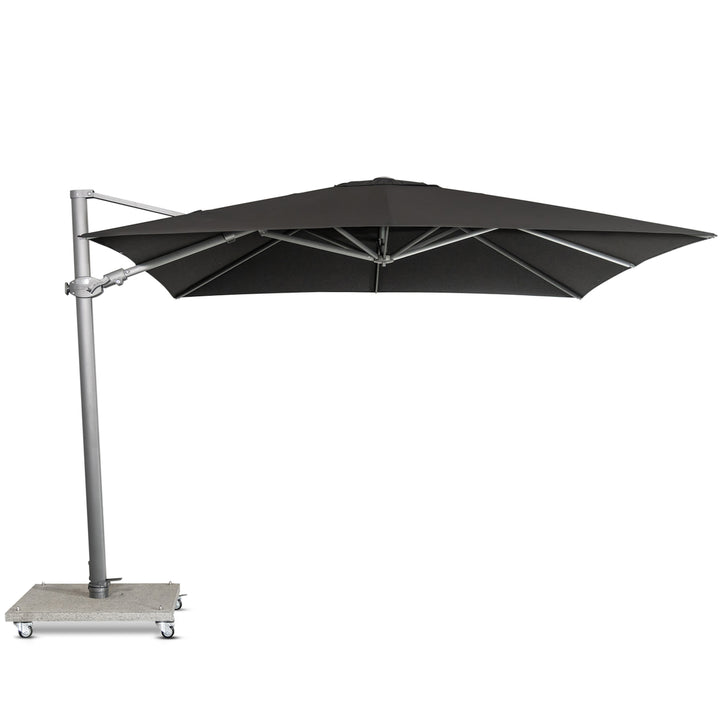 A large, black cantilever umbrella extends from a metallic pole with a wheeled concrete base, situated against a plain white background.