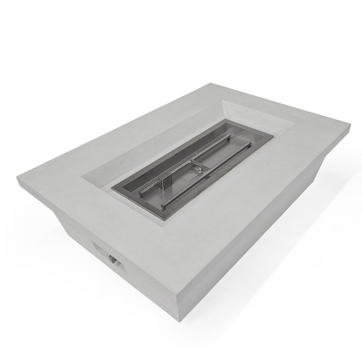 A rectangular, gray concrete fire pit table features a central metal burner insert. The setting is minimal, suggesting a modern and sleek design for outdoor or patio use.