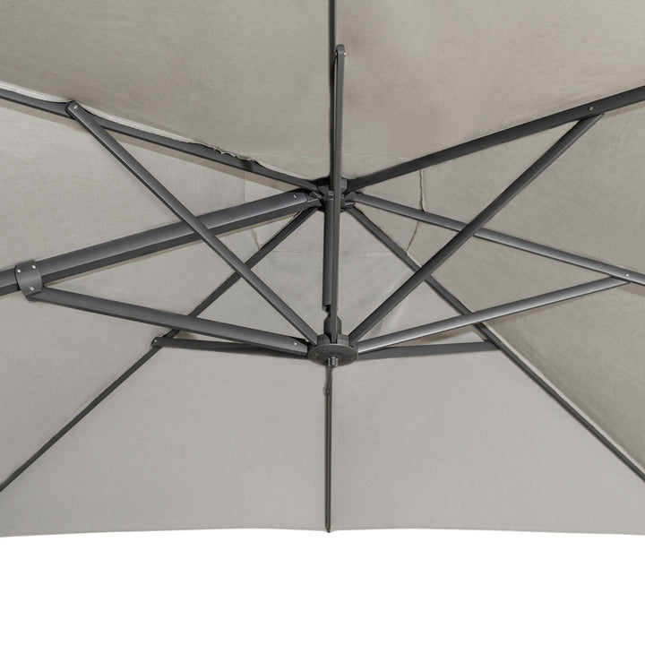 Gray patio umbrella; metal ribs extend from the central hub, forming a supportive framework. The perspective is from underneath, showcasing the umbrella's underside structure in a neutral setting.