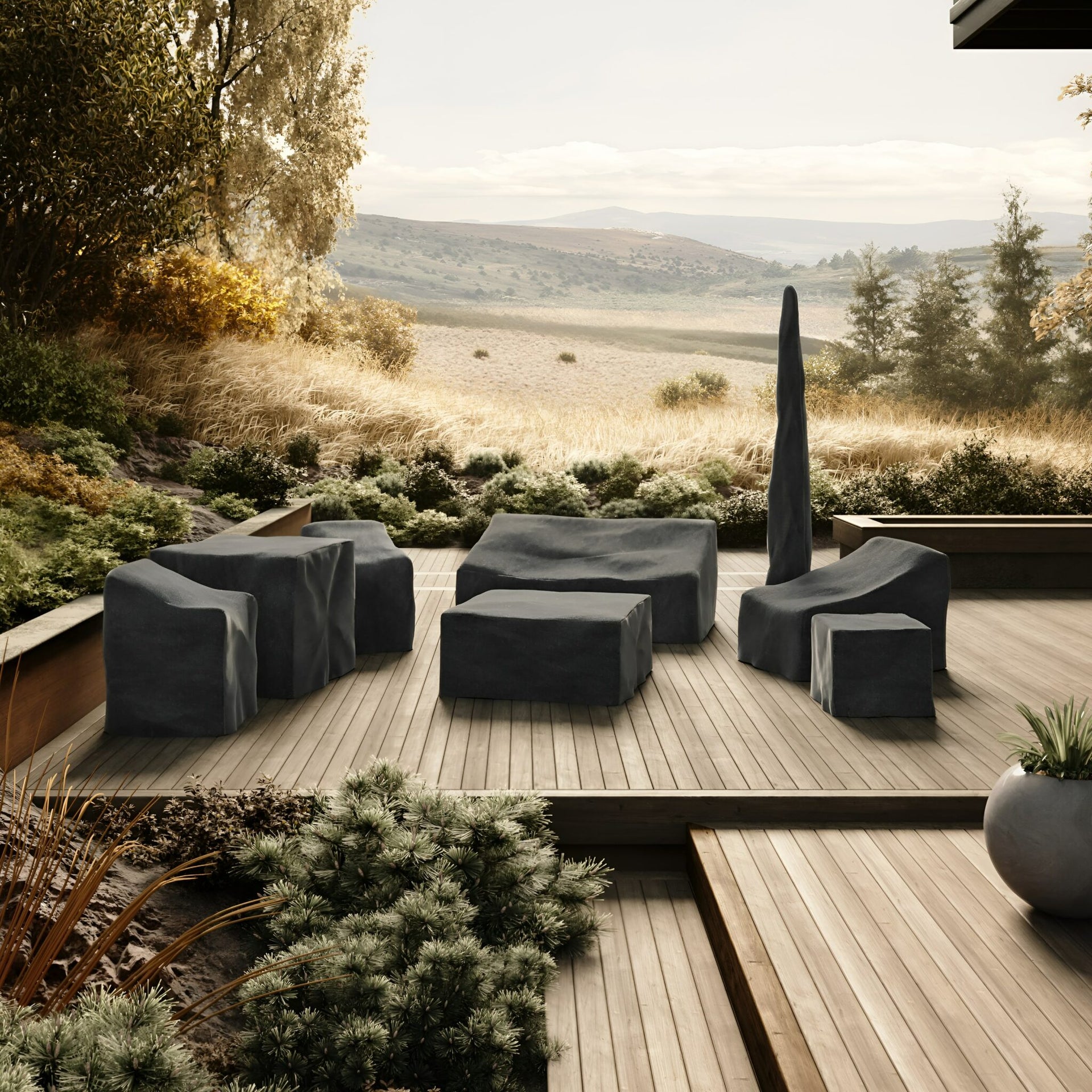 Outdoor furniture sits on a wooden deck, covered with protective covers, and surrounded by lush greenery. In the background, rolling hills and a serene landscape stretch to the horizon.v