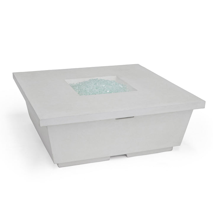 A square, white fire pit table with crushed glass in its center; no flames are present. It rests on a flat surface, against a plain white background.