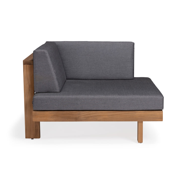 A modern corner sofa with grey cushions is placed on a wooden frame. The setting is minimalist, with a stark white background highlighting the furniture's design.