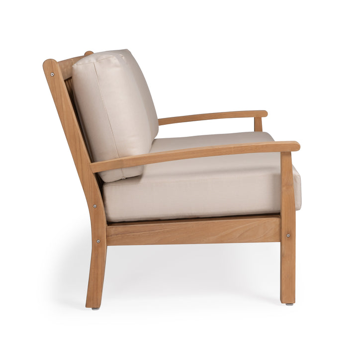 A wooden chair features beige cushions, angled within a simple, minimalistic design. It is situated on a plain white background, highlighting the chair's clean lines and natural wood grain.