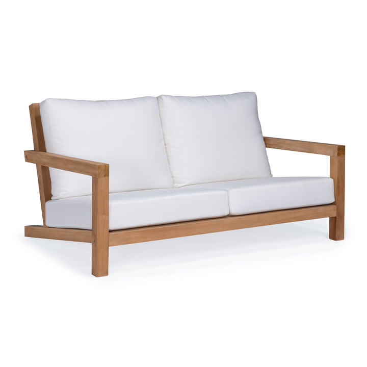 A wooden-framed sofa with white cushions sits in a minimalist setting, highlighting its clean and modern design.