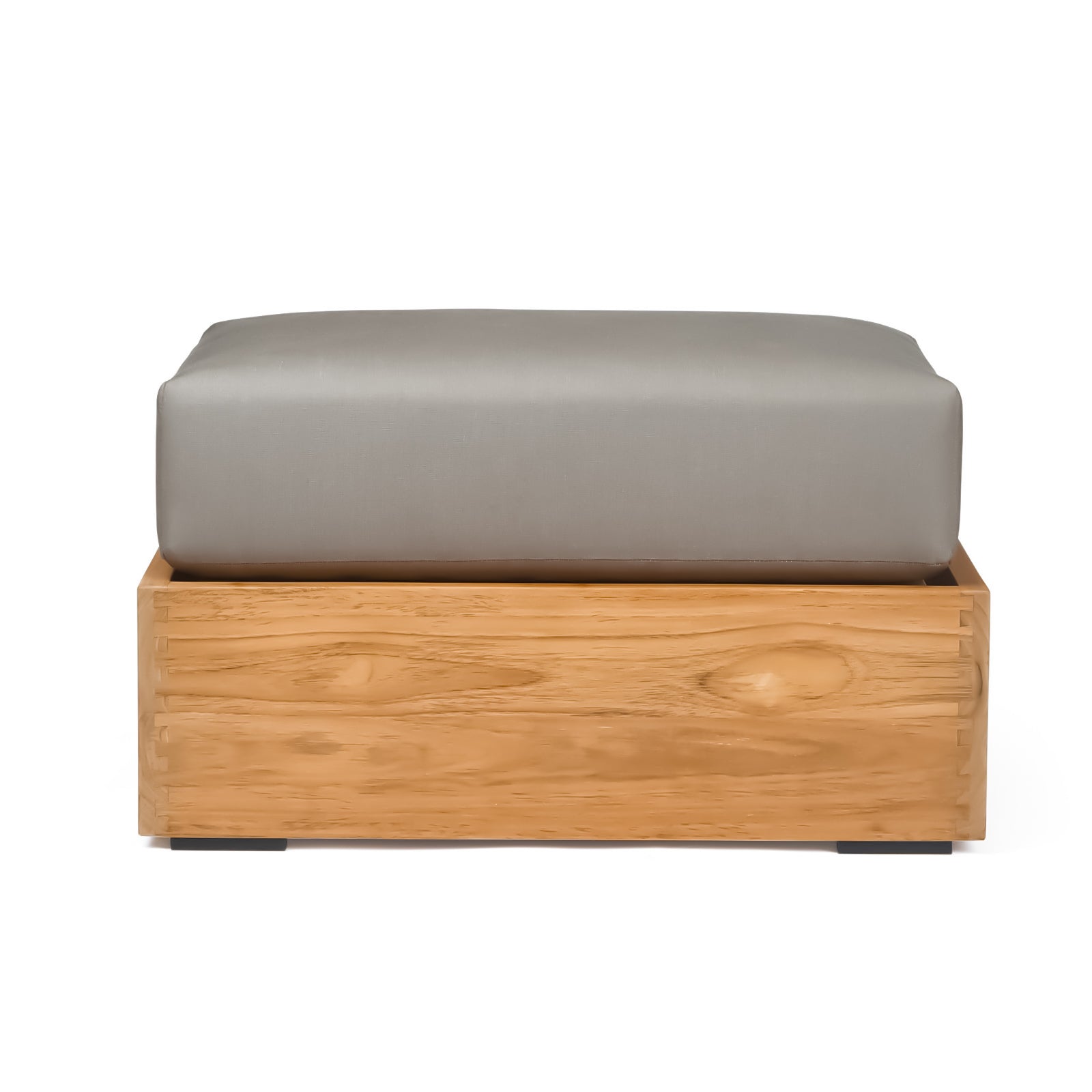 A rectangular wooden ottoman features a light gray cushion on top, resting against a plain white background.