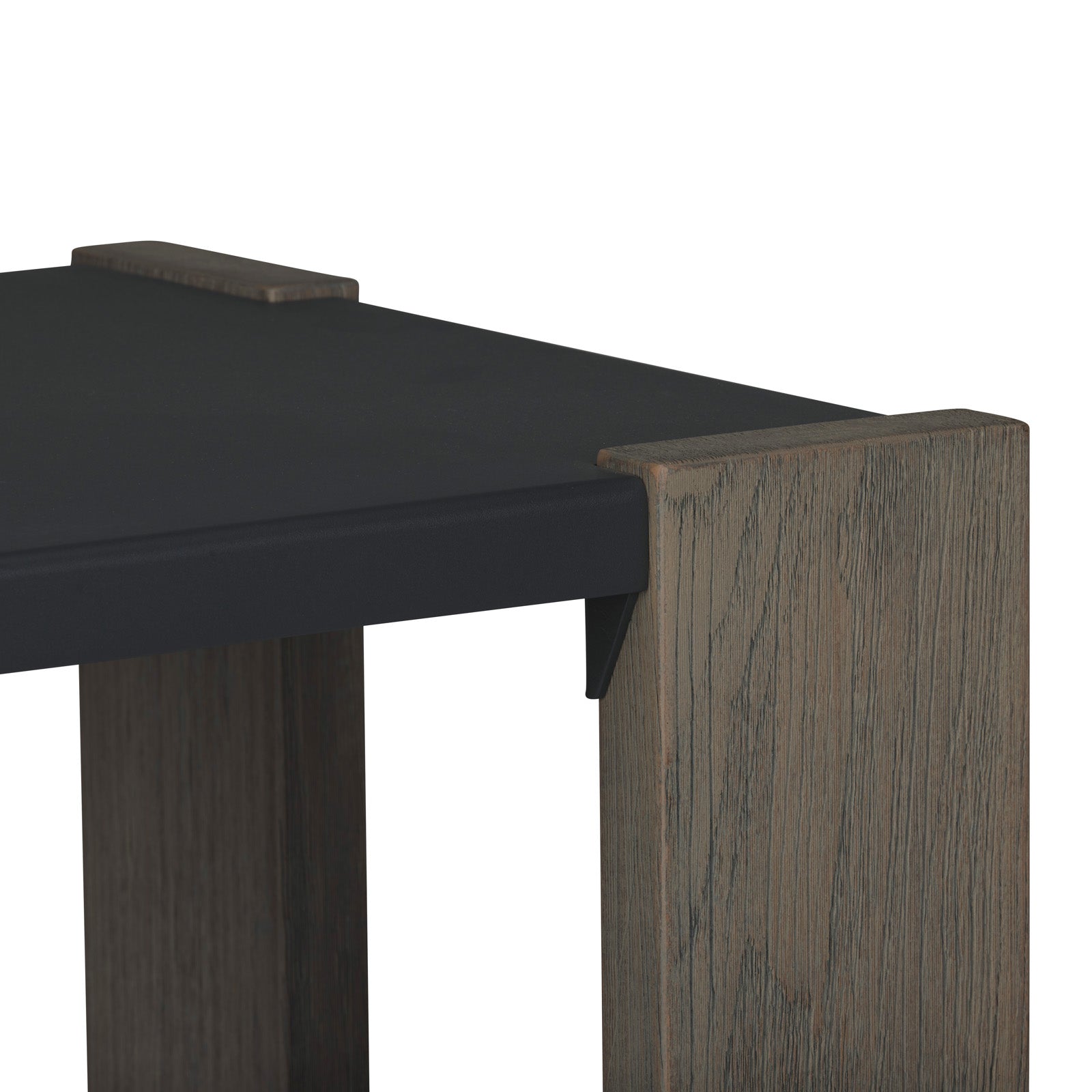 A table corner featuring a dark tabletop and wooden legs with a textured grain pattern, set against a plain white background.