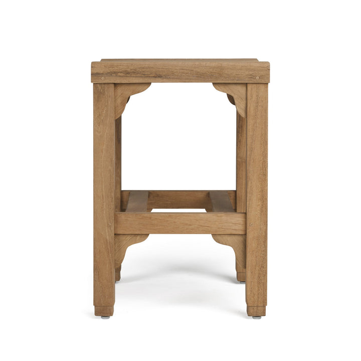 A wooden stool stands upright, showcasing a square seat and sturdy legs with decorative supports, placed on a plain white background.