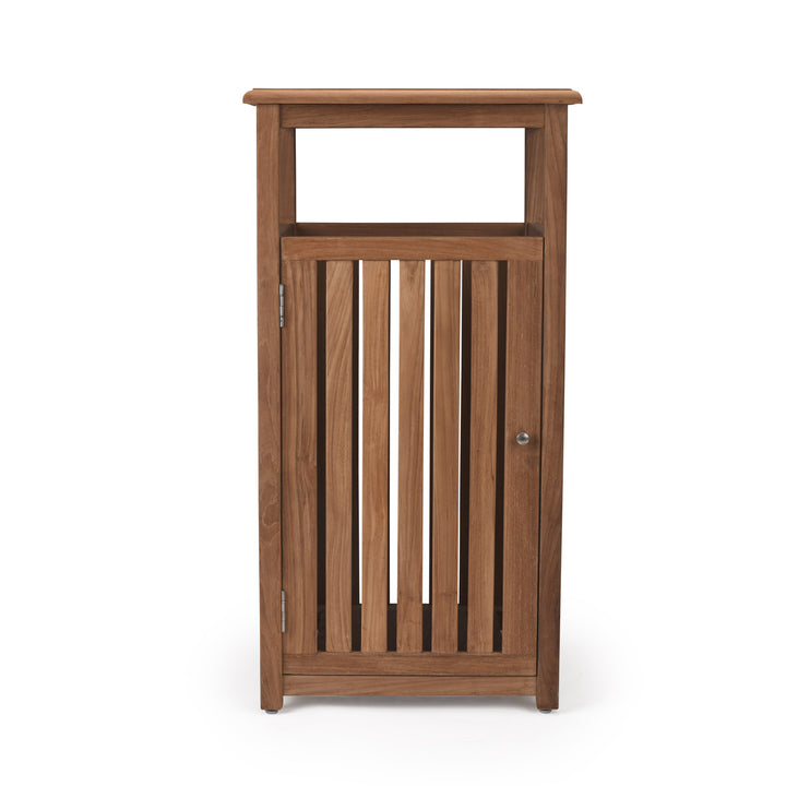 Wooden cabinet with vertical slats forms the door, allowing a partial view inside. Positioned in a plain, neutral space, it stands on four small legs with a knob on the door.