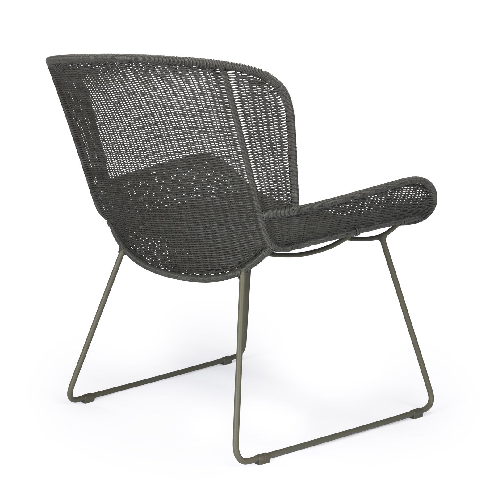 A dark, wicker chair with a metal frame stands stationary in a studio setting, highlighting its woven texture and minimalist design.