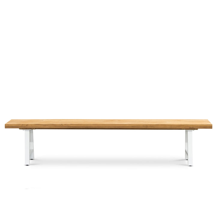 A wooden bench with a simple, flat surface rests on two sleek, white metal legs against a plain white background.