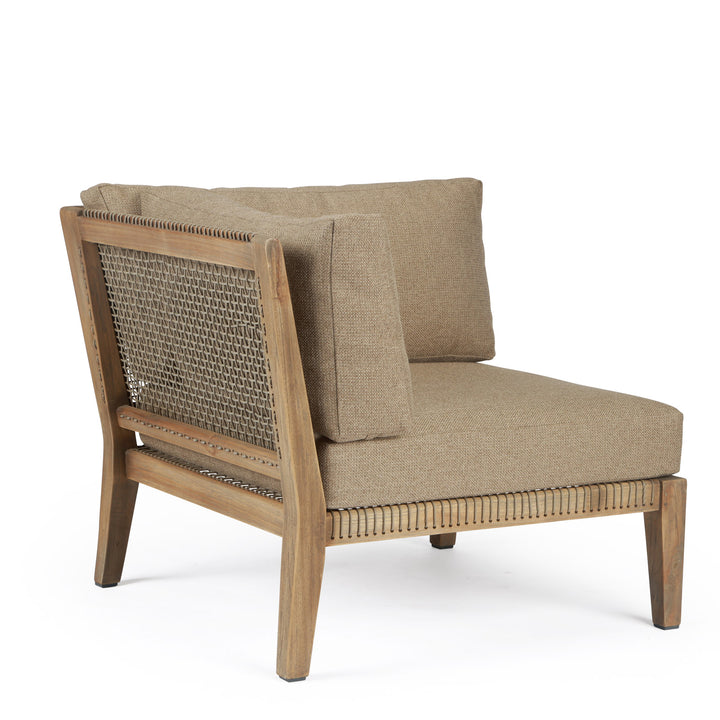 A beige cushioned chair with a wooden frame and woven backrest is positioned in a neutral, white space. The design combines a modern aesthetic with a classic touch.