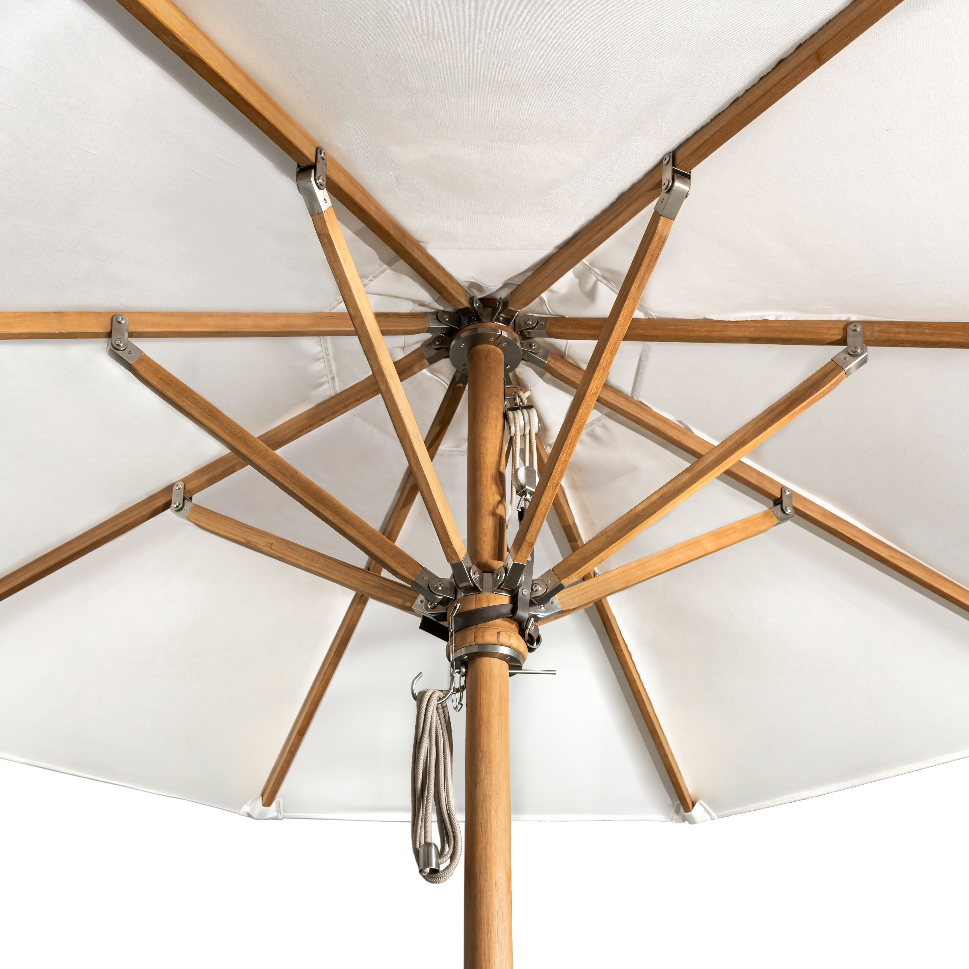 A patio umbrella, with wooden ribs extending outward, supports a taut white canopy. The central pole features rope and metal fixtures, suggesting an outdoor setting.